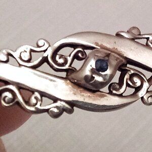 silver pin with small sapphire